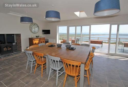 The spacious dining area has lovely sea views, and shares a double-fronted woodburner with the adjac
