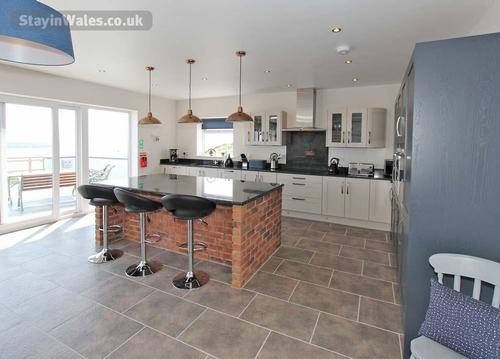 The modern, fully fitted kitchen is extensively equipped, and the island can be used for extra works
