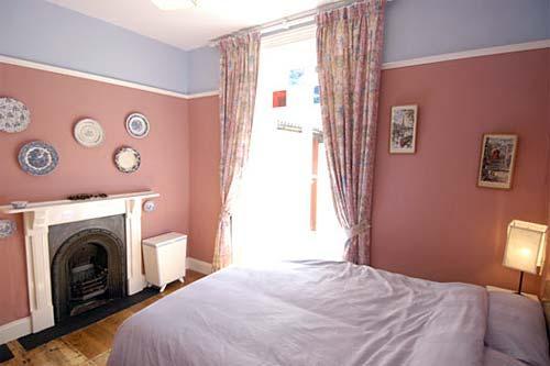 Rear bedroom downstairs has original stained glass windows and is also full of charm.