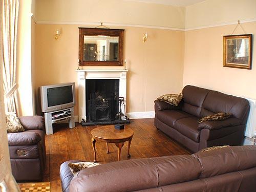 The spacious, light and airy lounge with a lovely fire to snuggle up in front of.