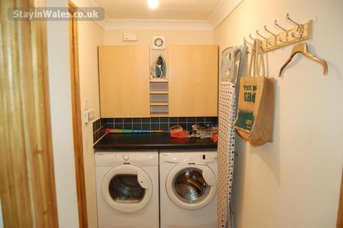 The utility room is furnished with a fully automatic washing machine and tumble dryer.