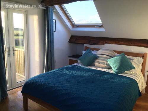Bedroom in Ysgubor Hen french doors leading on to balcony
