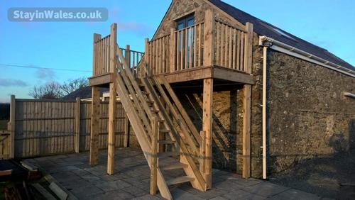 Balcony and stairs leading from bedroom at Ysgubor Hen