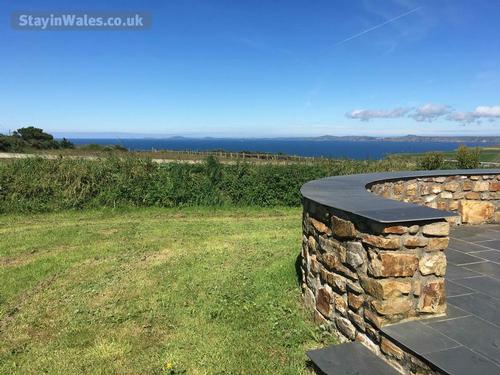 Grassy garden with slate terrace and sea view