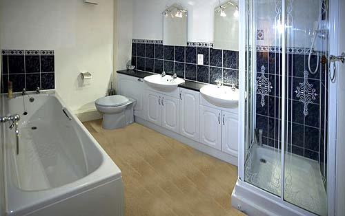 Bathroom with double sink, bath, shower and toilet