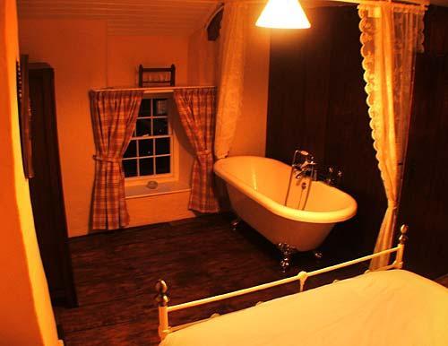 The master bedroom has a kingsize bed and double-ended roll-top bath.