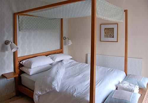 The master bedroom has a 5ft teak four poster bed