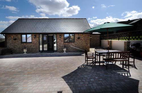 Front view of Winchfawr Lodge including parking and patio area.