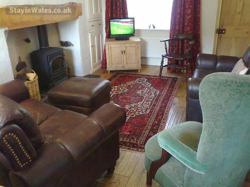 The living room with inglenook fireplace and woodburner