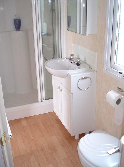 The bathroom has a full size shower, bath, washbasin and loo