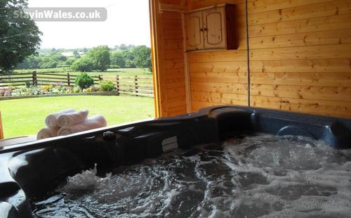 Hot tub enclosed in a log cabin.