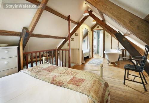 Gorgeous Kingsize bed under the eaves with that double-ended rolltop bath too
