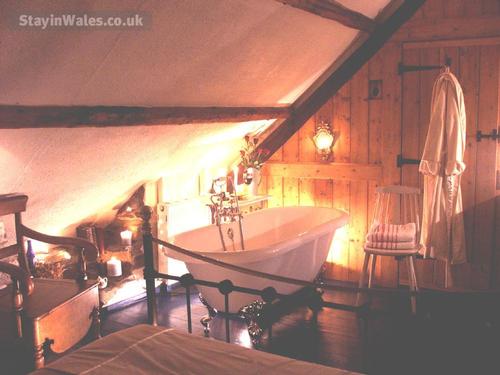 Under-eaves bedroom with Kingsize bed and that double-ended Rolltop Bath