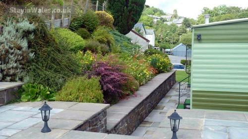 The area around the caravan is paved and there's a sitting area with outdoor furniture