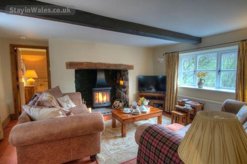 Characterful living room with exposed beams, luxurious sofas, real fire, and smart TV with fibreopti
