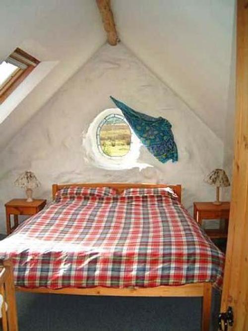 Oval window in main bedroom of Converted Cowshed