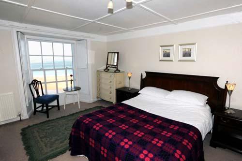 Bedroom in Dewi Emrys flat with a double king size bed and a single bed, there is also a double sofa