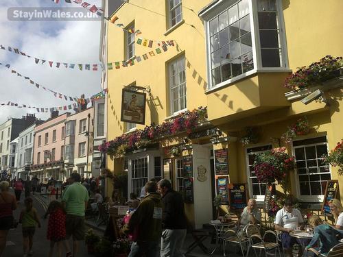 Pedestrianised Tenby during the School Summer Holidays with pavement dining areas.