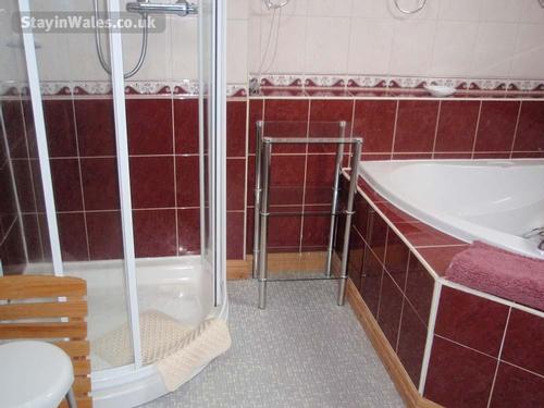 Bathroom has a corner bath and separate shower