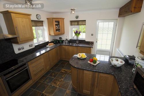 Kitchen-diner with granite worktops and breakfast bar at Rhos Wen Cottage