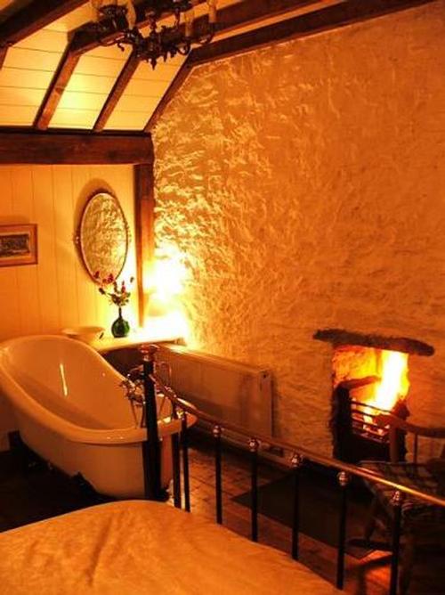 King size bedroom with fireside roll top slipper bath, tv, DVD player and en-suite shower room