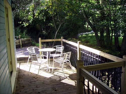 The cottage has a decking area overlooking the river