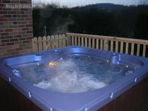 HOT TUB at night on decked area.