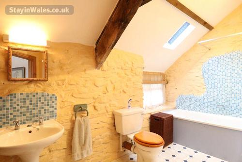 The bathroom with bath and shower over
