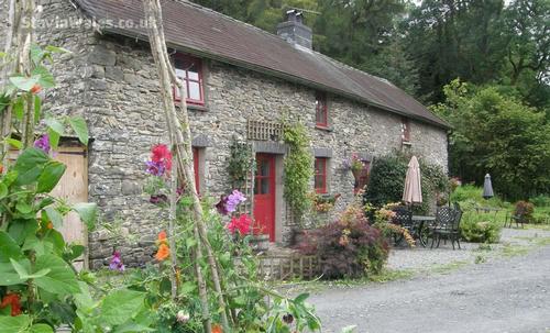 Y Stabl Cottage with patio area in front of it