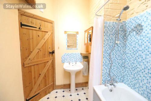 The bathroom with bath and shower over